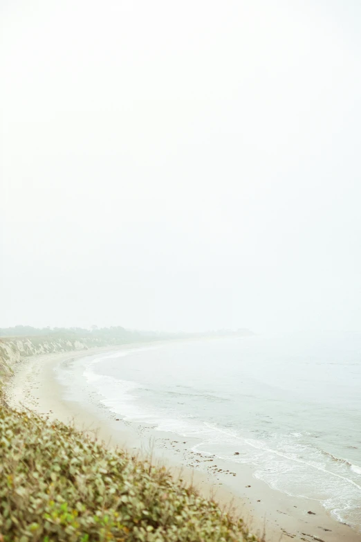 the man is walking along the edge of the water