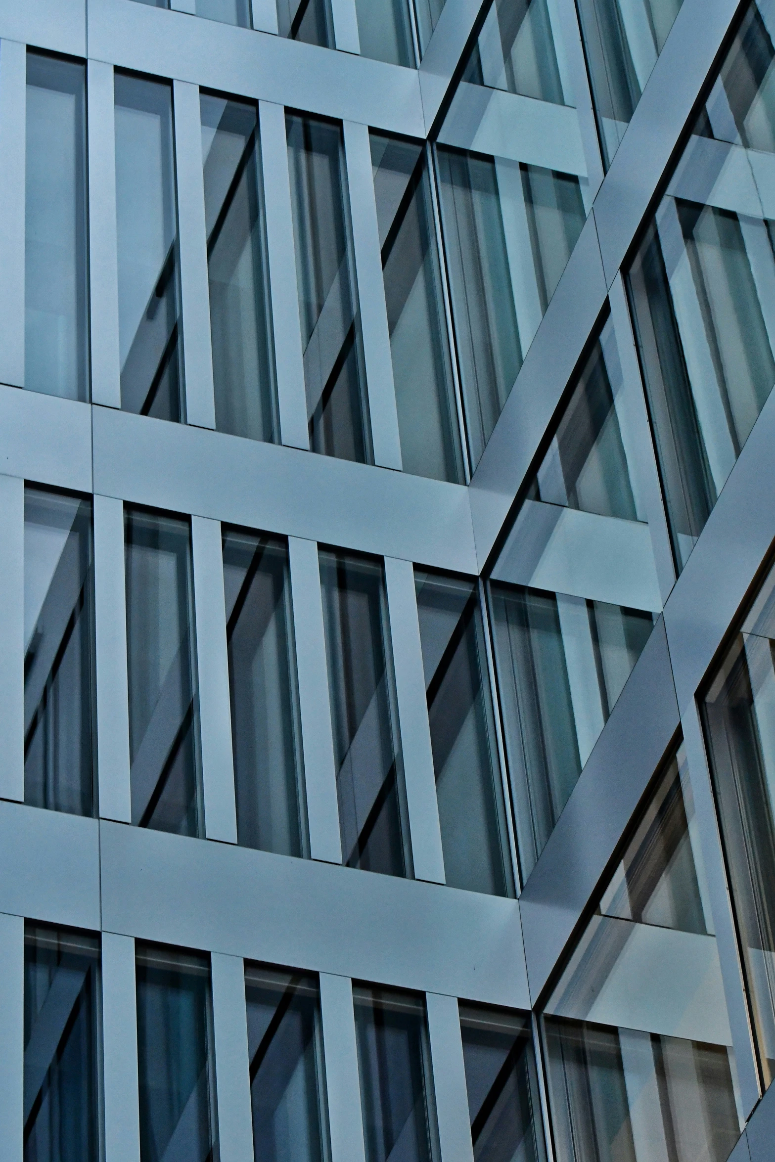 glass window of a gray building with a clock in the middle of the frame