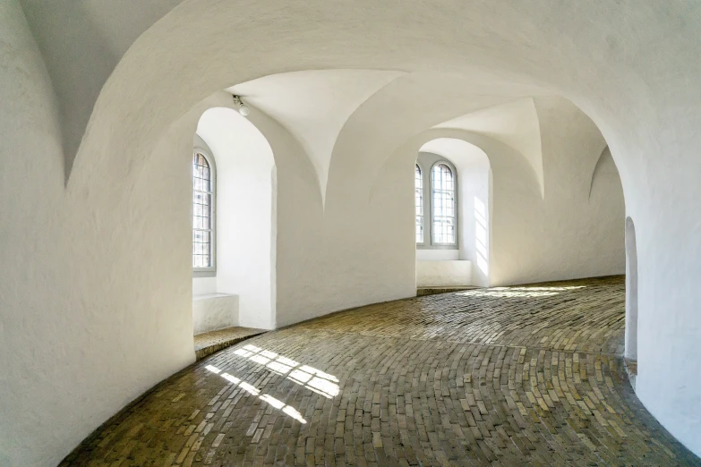 an arched room with white walls and a floor