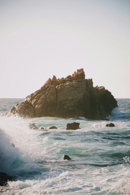 a rocky beach in front of the ocean on a clear day