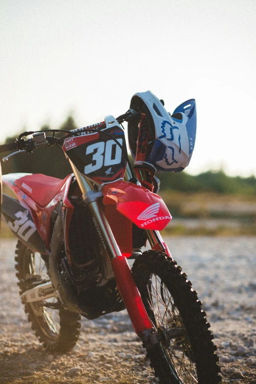 a red dirt bike parked on a street