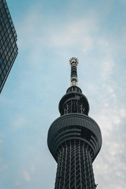 the top of a tall tower with a large metal object on it's face