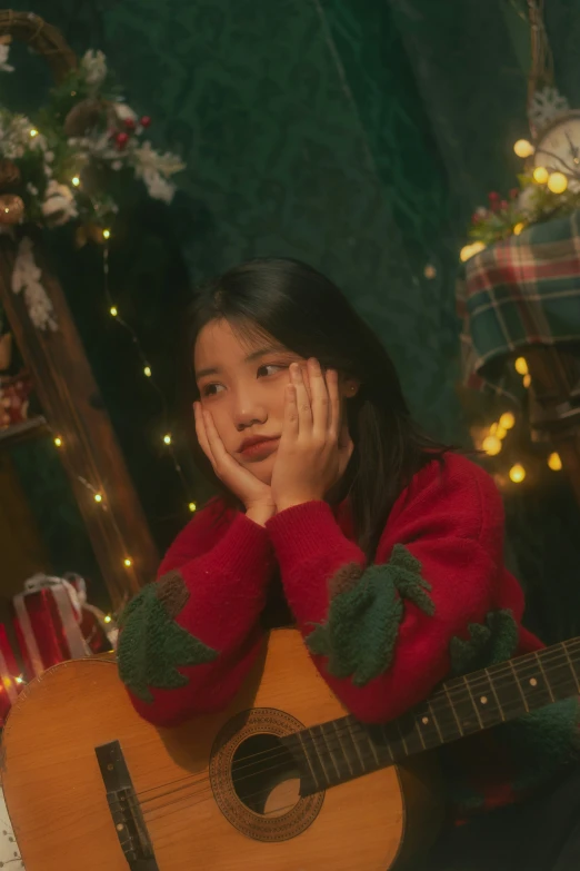 a child playing a guitar in front of christmas decorations