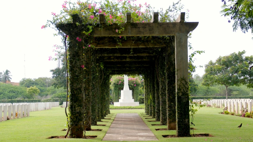 some long benches in a park near a white statue