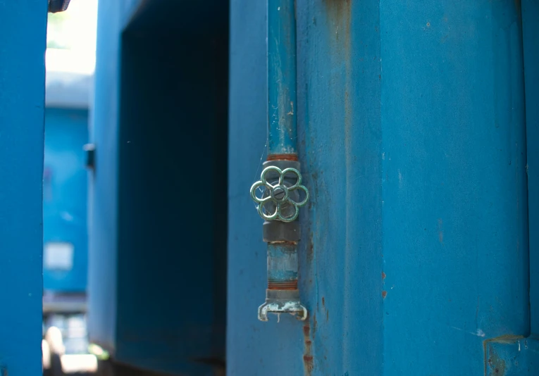 an old lock on a bright blue pole