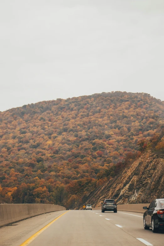 cars riding on the road near a mountain range