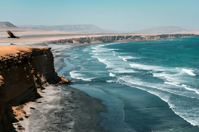 the view from the top of the cliff looking at a beach and ocean