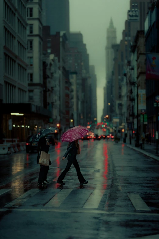 two people walking on a street holding umbrellas