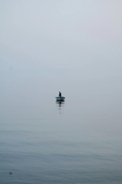 a person is paddling a small boat out in the middle of the ocean