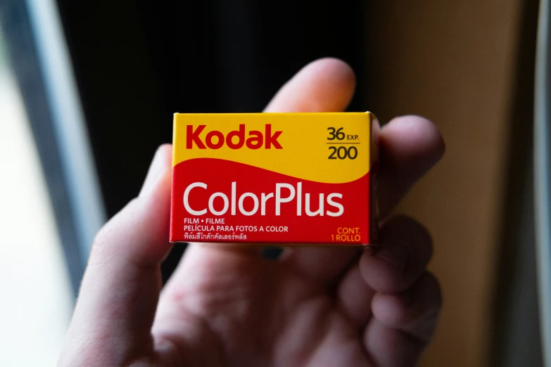 a person holding a box of kodak colorplus