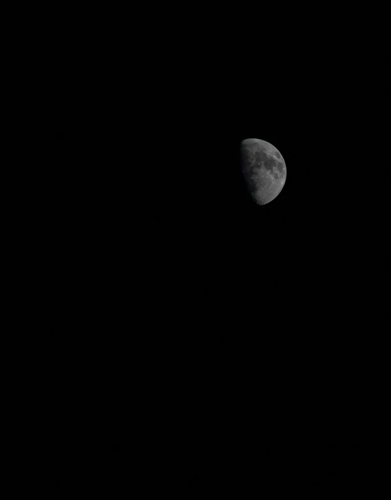 a moon is visible in a dark black sky