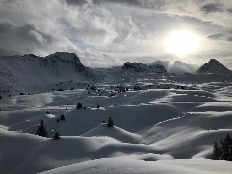 the sun is behind a mountain peak with snow