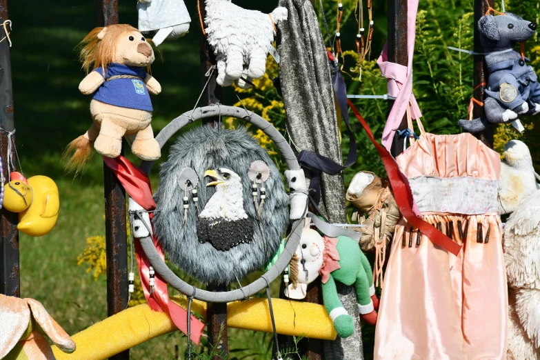 a bunch of stuffed animals hanging from a pole