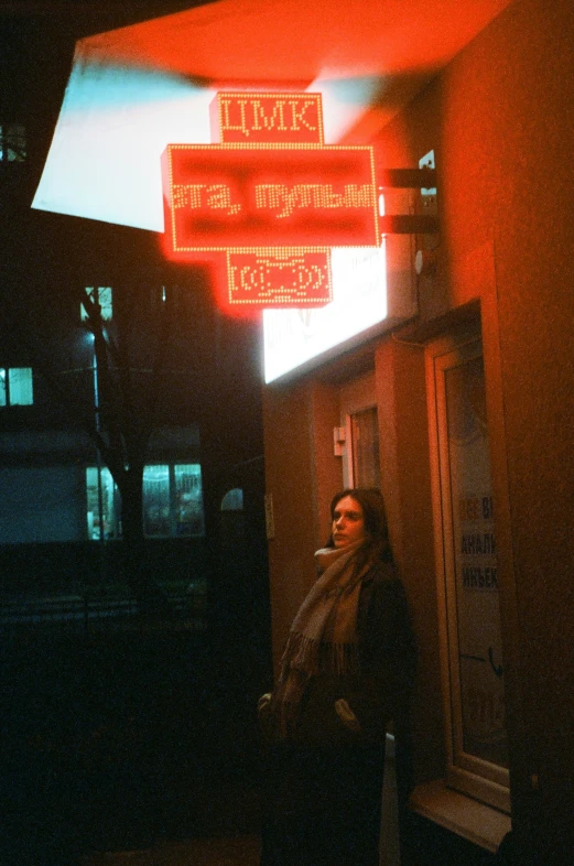 a woman standing underneath a red sign for traffic control