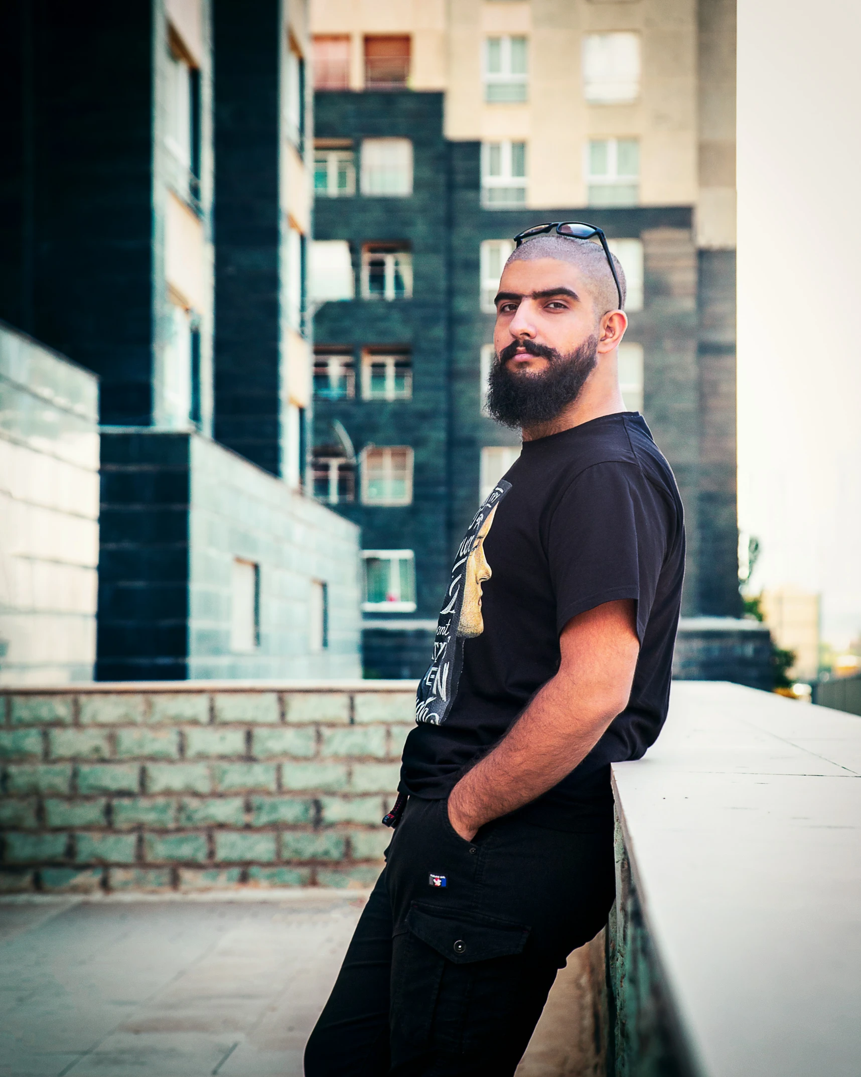 a man sitting on the ledge of a building