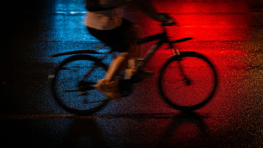 this man is riding his bike through the street in the dark