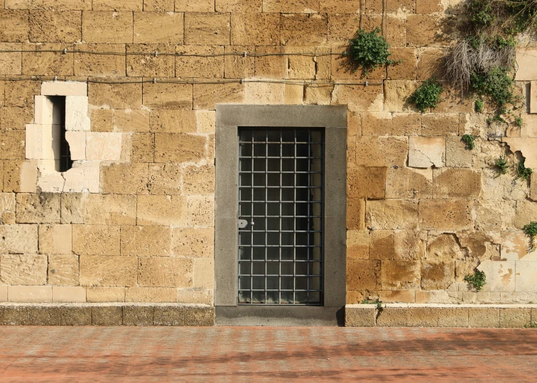 a yellow brick wall with windows and a stop sign