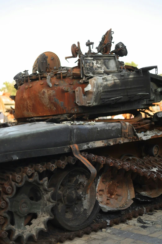 rusty tanks stacked to the ground in a junkyard