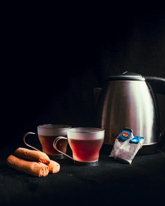 a kettle, mug and two  dogs next to it