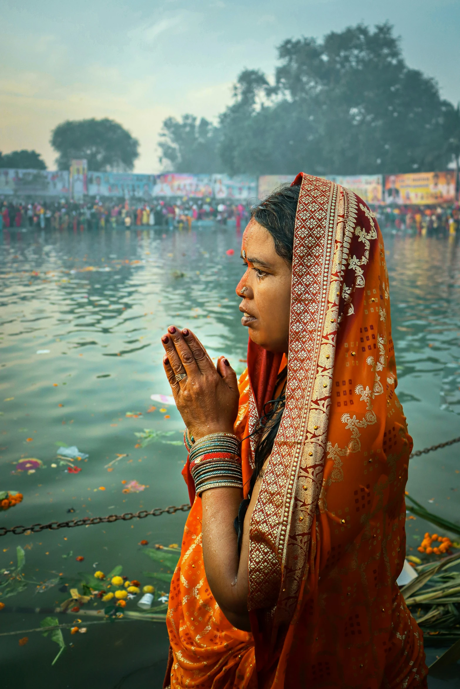 woman praying by the water in india