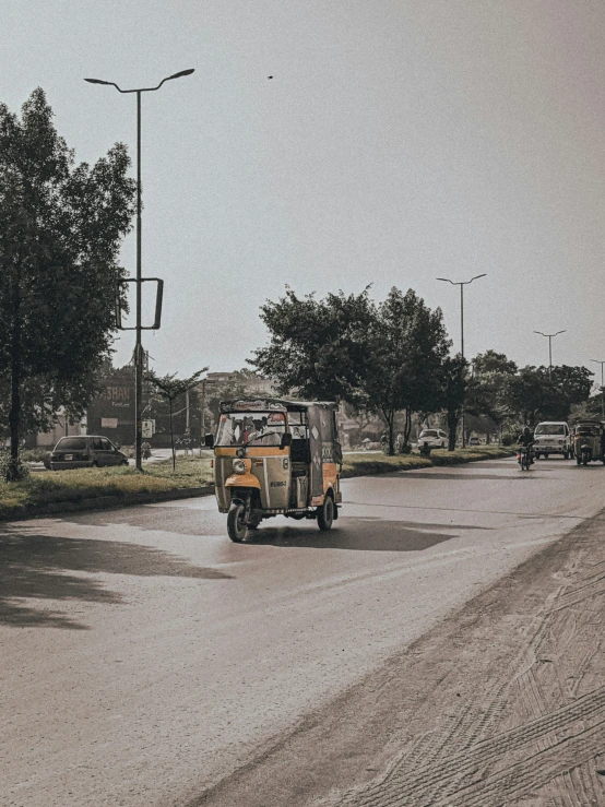 two people ride on the back of a jeep in the middle of the road