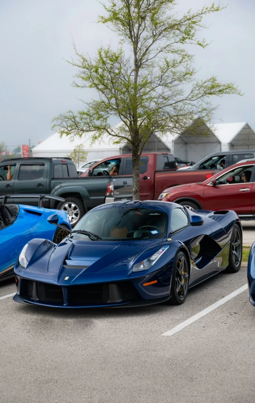 a blue supercar parked next to another one in a parking lot