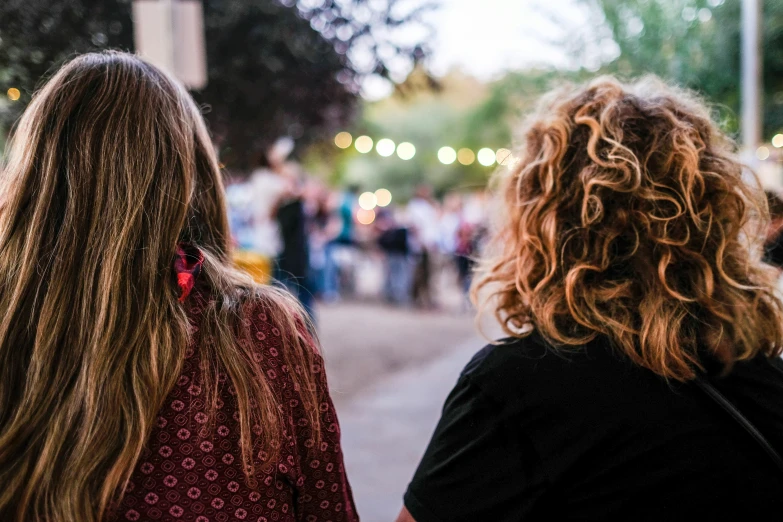 two women walking down a street while looking at soing