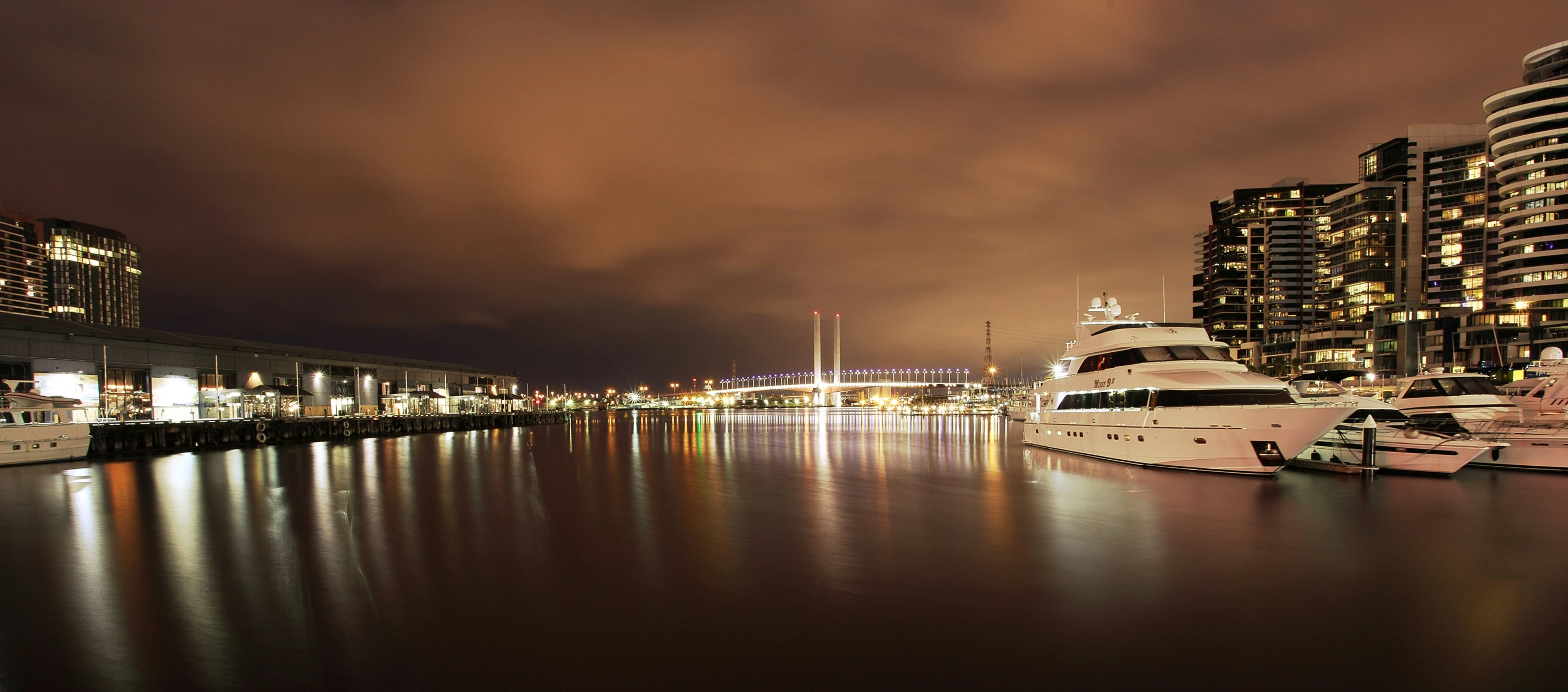 a bunch of boats floating in the water at night