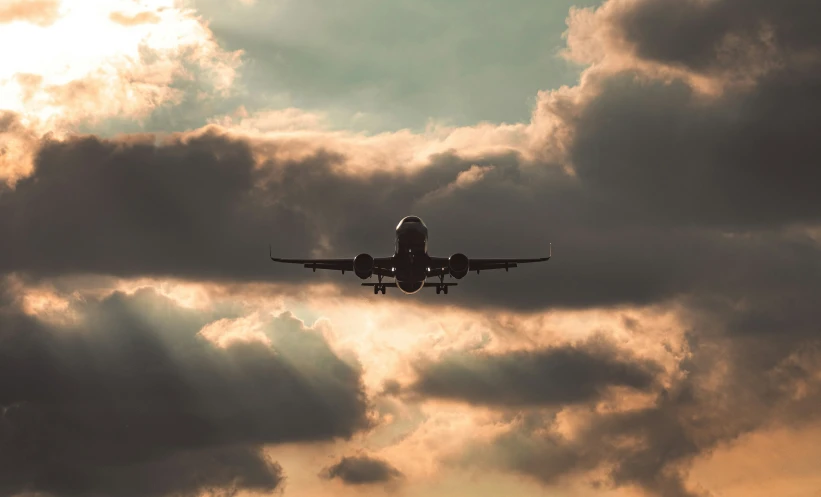 the airplane is flying through the cloudy sky