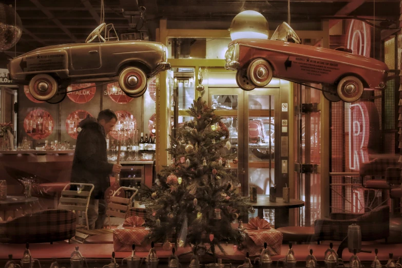 vintage cars hang in the store as a man looks on