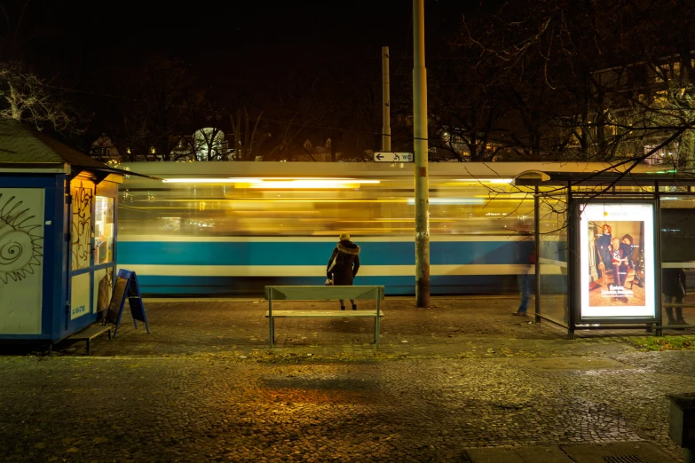 bus drives by a bus station as the train goes by