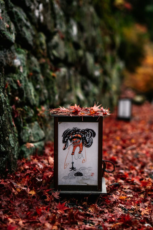 a sign on a leaf covered trail near a tree