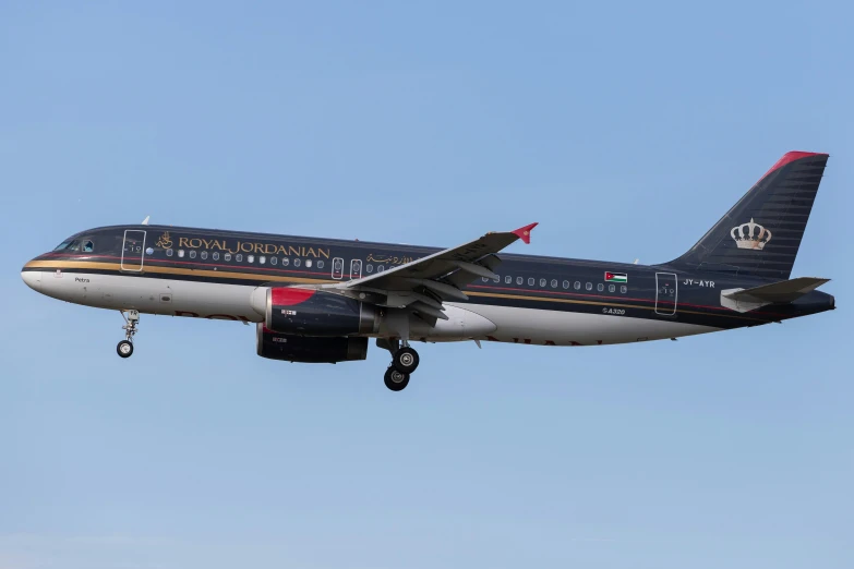 a white, black, and red airplane flying against the sky