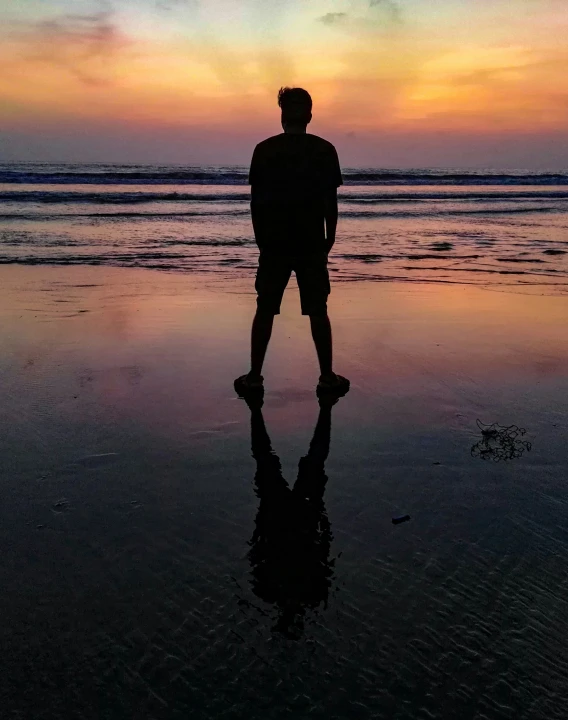 a man in silhouette on the beach during sunset