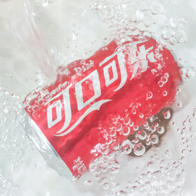 a red soda can with the chinese writing coca - cola on it