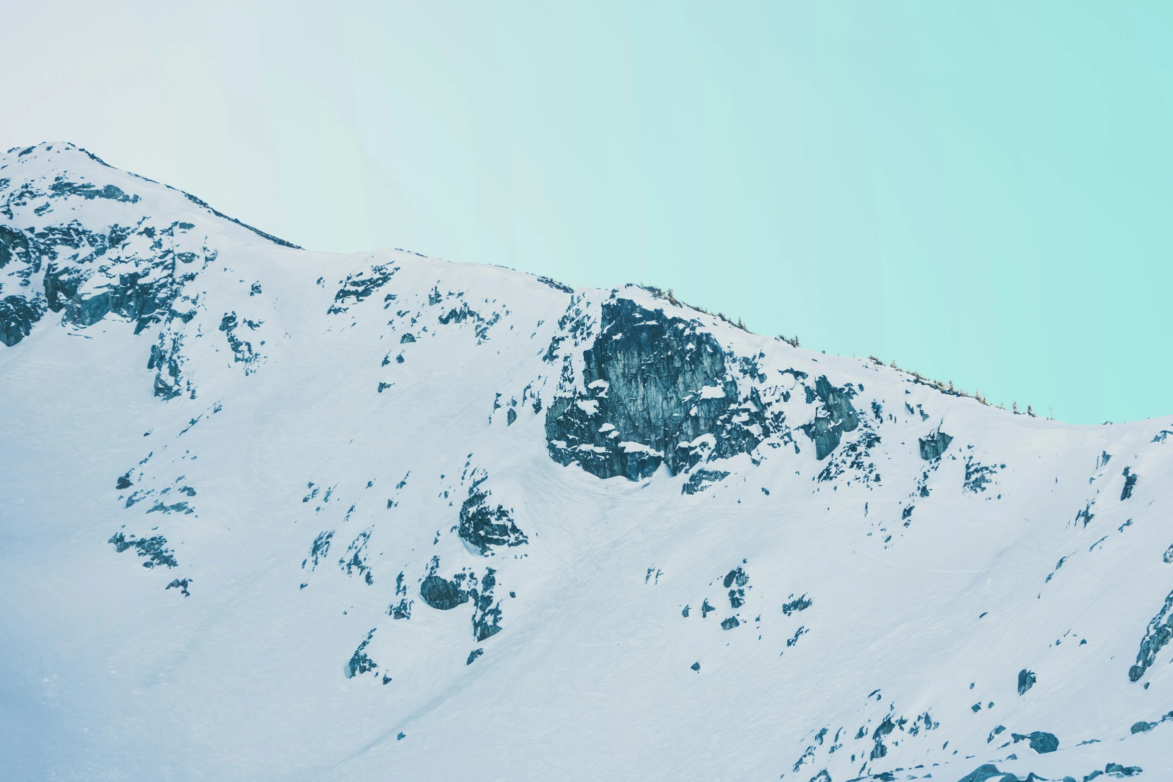 a very large mountain with some clouds and snow