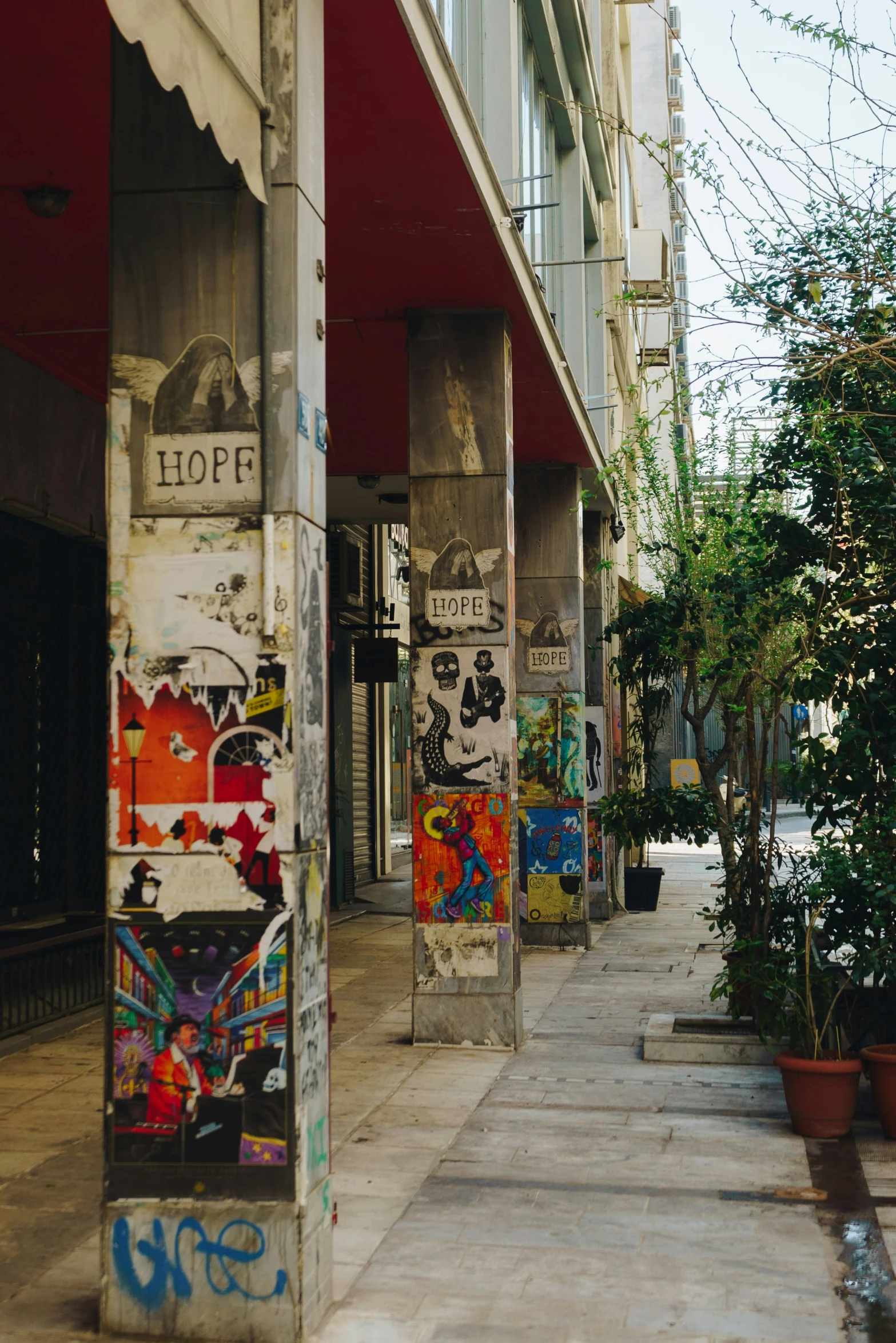 a sidewalk lined with walls covered in graffiti