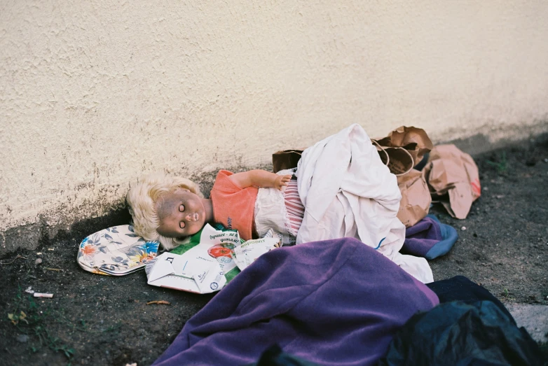 two young children laying on the ground in front of a wall