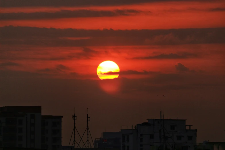 the sun is setting in the dark cloudy sky