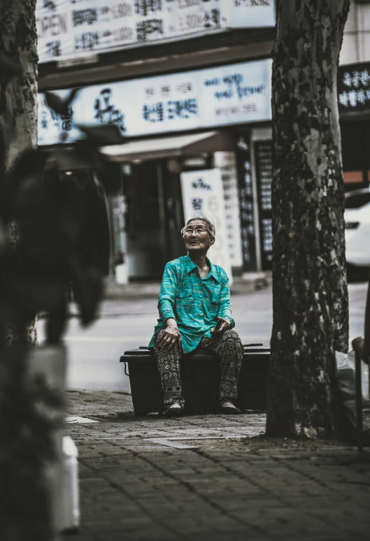 a woman sits on a bench with her suitcase