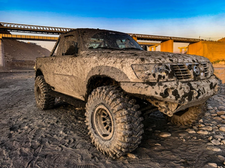 the mud covered truck is parked on the beach