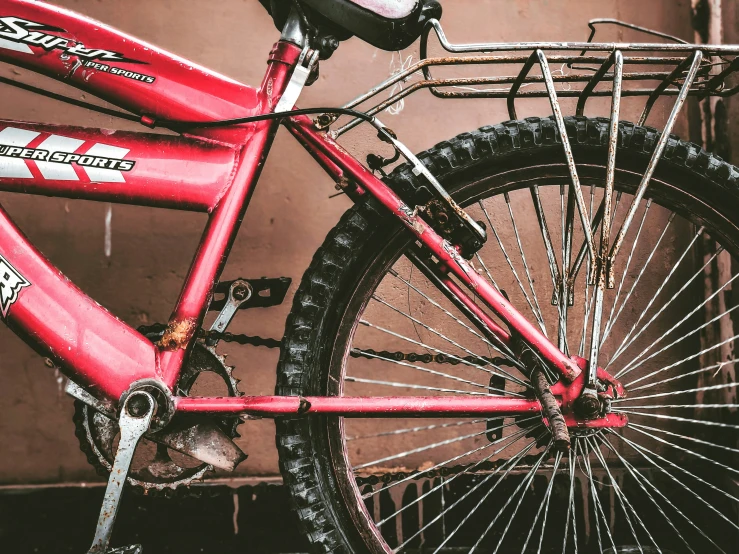 a red bike parked next to a tall building