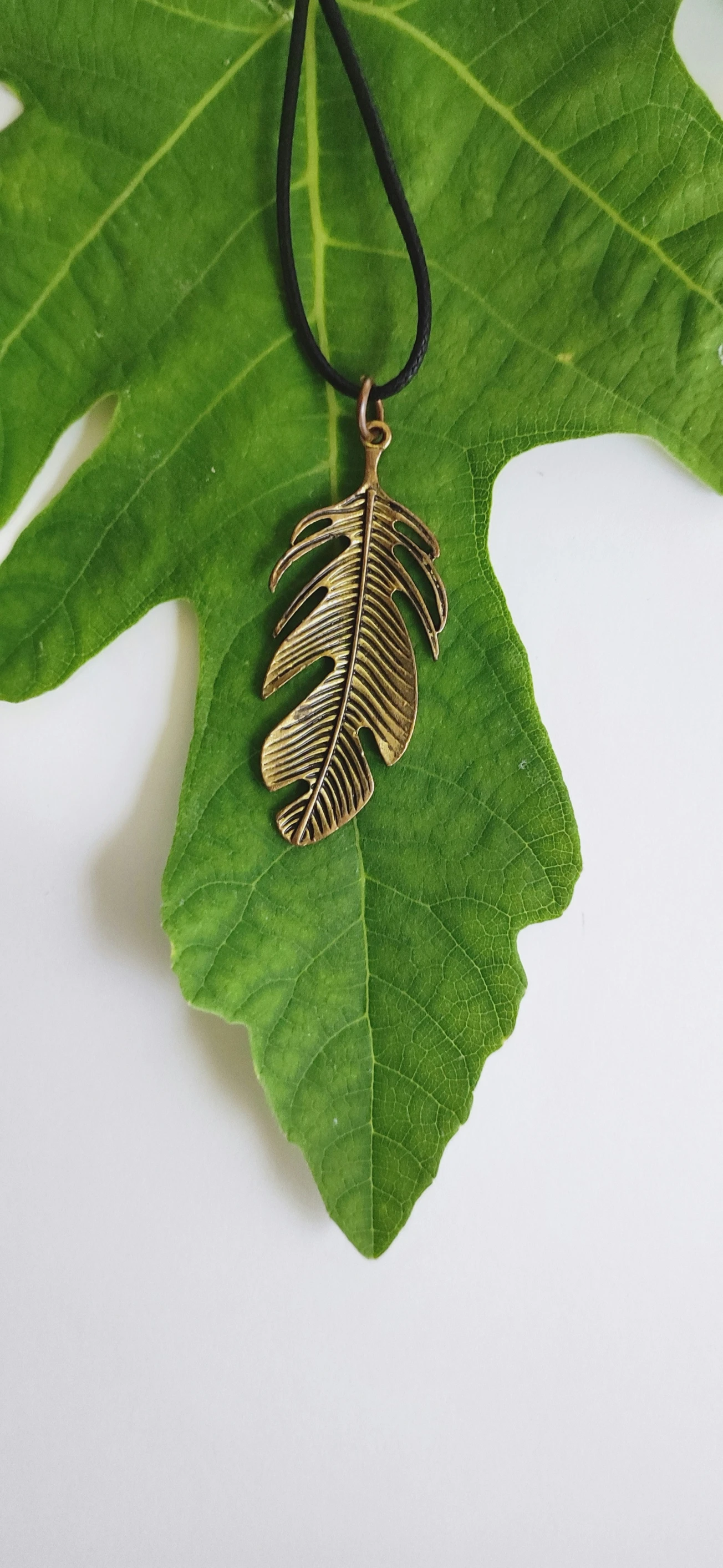 a necklace that has two ss leaves attached to it