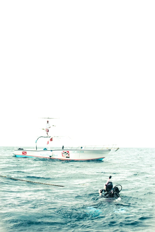 a man is kayaking with a boat in the background