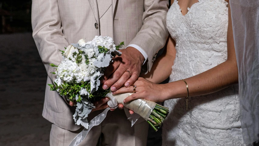 a bride and groom holding hands during the wedding ceremony