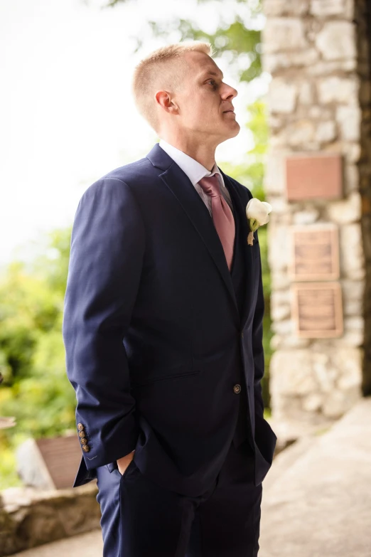 a man in a suit poses for the camera