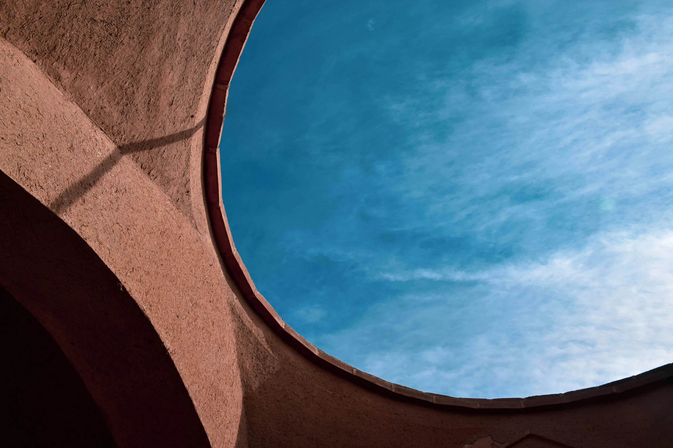 a window in the side of a building looks into the sky