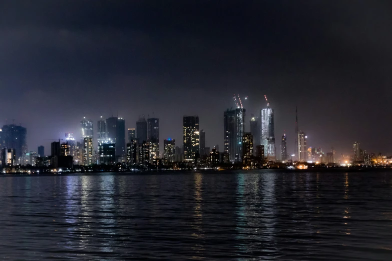 city skyline at night from the water with reflections