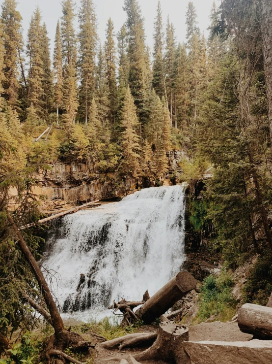 a waterfall that is falling over rocks in the woods