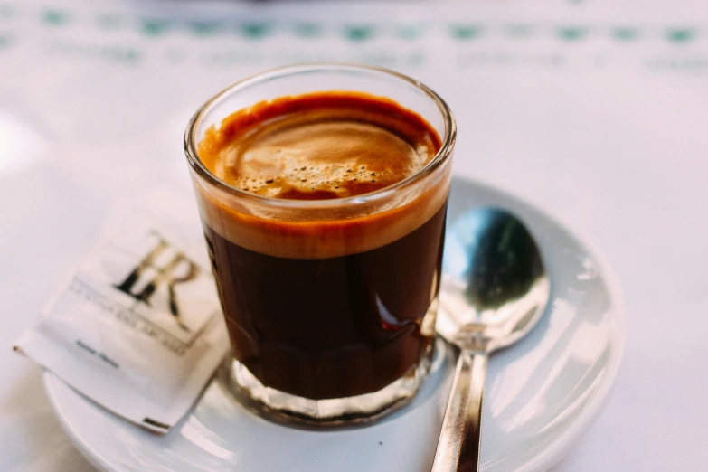 a cup of  chocolate coffee next to a spoon